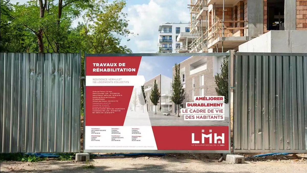 Panneau de chantier LMH « Travaux de réhabilitation » posé sur une palissade devant un immeuble en construction