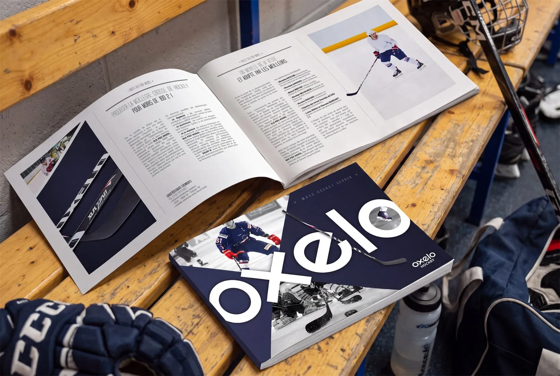 Catalogue Oxelo ouvert sur un banc de vestiaire, entre gants et crosses de hockey